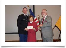 Matthew Walters holds the Ed Ramsey Scholarship Award Presented by Dr. Raquel Ramsey while Col. Ed Ramsey Jr. holds the Saber.